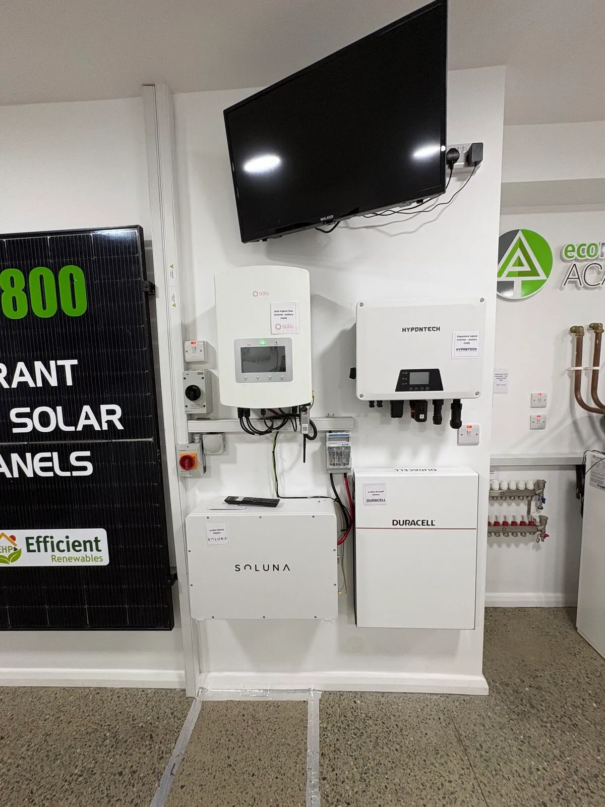 Solar PV panel, inverters and home batteries mounted on the Efficient Renewables showroom display wall