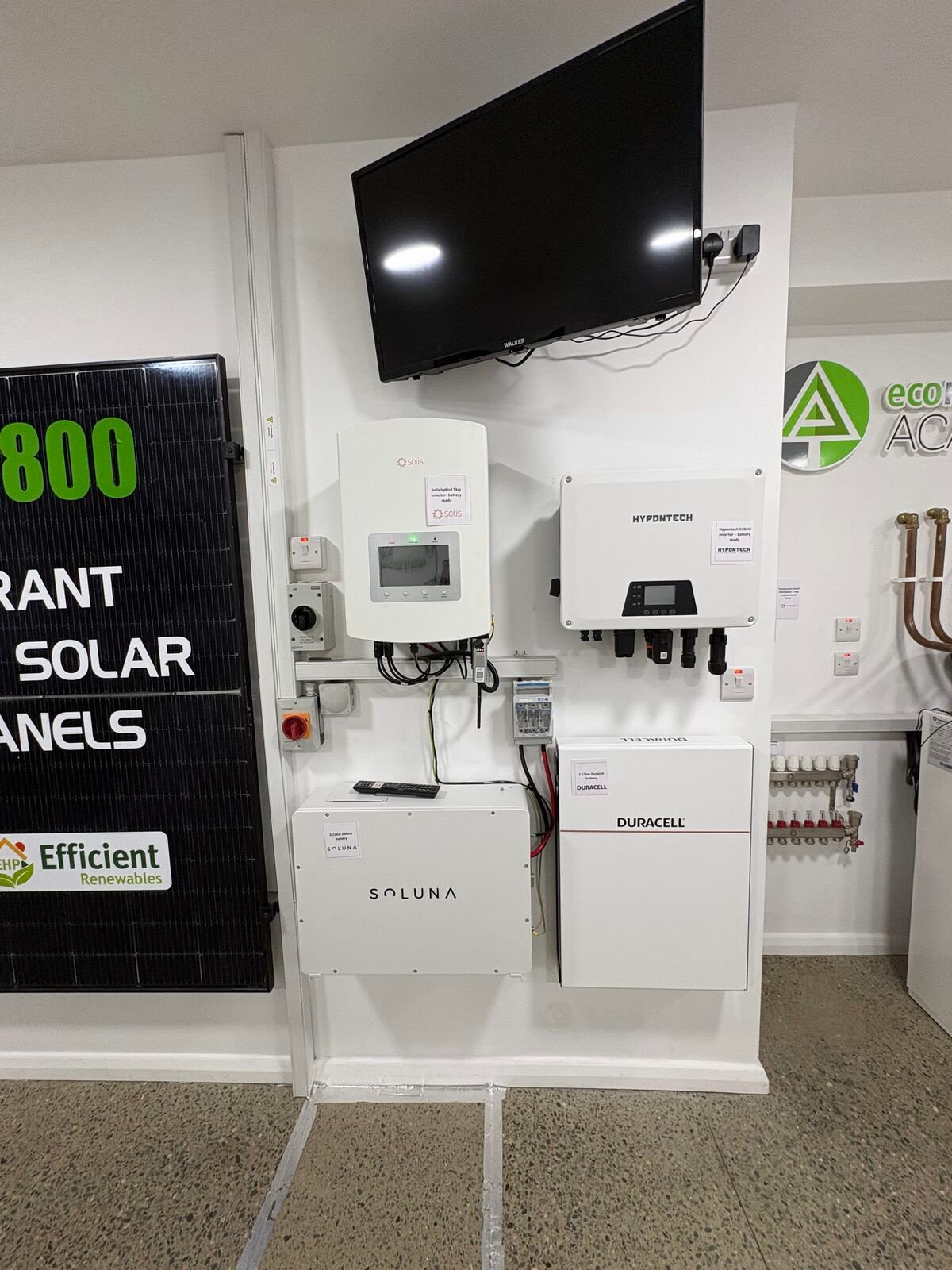 Solar PV panel, inverters and home batteries mounted on the Efficient Renewables showroom display wall